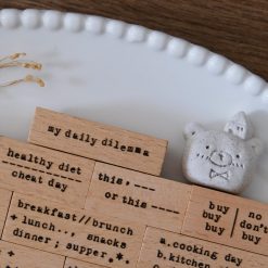 Styled detail of My Daily Dilemma rubber stamps by Eileen Tai with decorative ceramic figure.